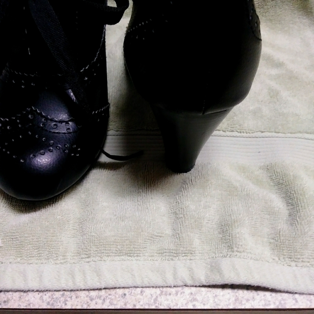 Black ankle boots with wingtip design and lace- up